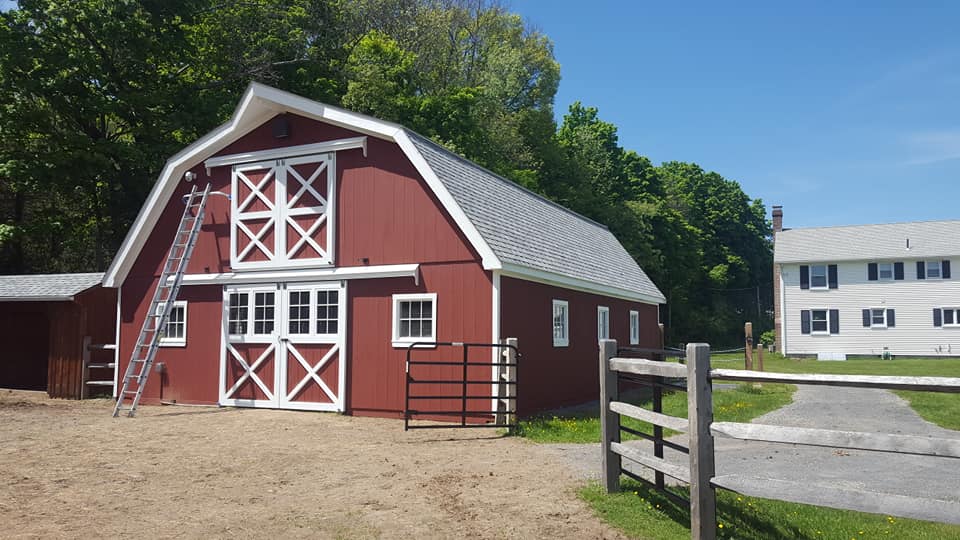 Finished painted barn in red with white trim on barn doors and windows